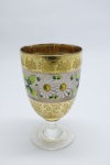 COLECIONISMO - Bela taça de coleção em demi cristal, no padrão veneziano. Corpo em tom rosado e realçado em tom dourrado com aplicação de flores em relevo, pintados a mão. Alt. 12,5 cm. Bolhas.