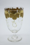 COLECIONISMO - Bela taça de coleção em demi cristal, no padrão veneziano. Corpo incolor e realçado em tom dourado com aplicação de flores em relevo, pintados a mão. Alt. 12 cm.
