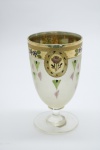 COLECIONISMO - Bela taça de coleção em demi cristal, no padrão veneziano. Corpo incolor e realçado em tom dourado com aplicação de flores em relevo, pintados a mão. Alt. 13 cm.