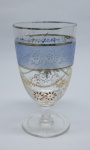 COLECIONISMO - Bela taça de coleção em demi cristal, no padrão veneziano. Corpo incolor e realçado em tom dourado com aplicação de flores em relevo, pintados a mão. Alt. 13 cm.  Bicados.