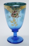 COLECIONISMO - Bela taça de coleção em demi cristal, no padrão veneziano. Corpo em tom azul e realçado em tom dourado com aplicação de flores em relevo, pintados a mão. Alt. 12,5 cm.