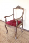 MOBILIÁRIO - Cadeira de braço, estilo inglês, em madeira nobre entalhada, assento estofado em veludo vermelho, esconsto no estado e florão central. Med. 105x58x49 cm.