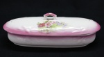 PORCELANA INGLESA - Peça de tocador em porcelana branca, tampa com faixa rosa floral. Med. 8x23x9 cm.