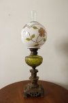 Antigo lampião a querosene, metal, alabastro, recipiente em querosene na tonalidade verde, cúpula em opalina branca, pintada a mão com motivos florais, possui manga interna. Alt. total 67 cm.