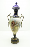 SEVRES - Antiga ânfora européia em porcelana azul cobalto, Século XX, corpo ovoide, decorado com reservas de cena galante e na outra face paisagem com estatueta de querubim, assinado pelo artista A. GABERT. Guarnecida em bronze ormulu, lavrado e cinzelado. Alt. 51 cm. Base com restauro antigo. Peça inclinada para direita.