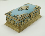 COLECIONISMO - Porta joia em opalna Sévres na cor azul turquesa, guarnecida com ricos adornos em bronze Ormulu em todo seu entorno e tampa com medalão central. Med. 8x19,5x9,5 cm.