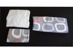 Jogo de cama juvenil em algodão nas cores azul e branco com círculos nas cores branca e tijolo.