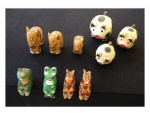 Dez escultórios executados em madeira pintados à mão sendo: 3 elefantes, 3 porquinhos, 2 sapos e 2 girafas, com pequenos lascados.