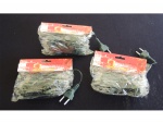 Três embalagens com lâmpadas brancas Natalinas, cada pacote com 100 lâmpadas.