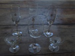 Sete peças em cristal sendo 3 flutes com logo, 1 taça para vinho tinto e duas taças para champagne,  De 22 a 9 cm.