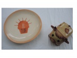 Duas peças em cerâmica sendo um prato  Luiz Salvador com brasão central `Le Turf` e uma queijeira representando vaquinha, Diam. 26, e 15 x 10, Alt. 10 cm.