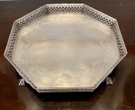 PRATA DE LEI - ANTIGA SALVA EM PRATA PORTUGUESA, FORMATO OCTAGONAL, GALERIA RENDILHADA E CINZELADA COM MOTIVOS FLORAIS, PLATÔ CINZELADO COM LÍRIOS D'ÁGUA E CONCHAS. QUATRO PÉS (UM AMASSADO) DE ÁGUIA AGARRANDO BOLA. MARCADA JAVALI. MARCA DO PRATEIRO E CHANCELA. MEDIDAS; 26,5 DE DIÂMETRO X 06 CM DE ALTURA. PESO; 805 GRAMAS.