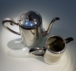 METAL PRATEADO - LOTE COMPOSTO POR UM BULE PARA CAFÉ, UMA LEITEIRA.MEDIDA DA MAIOR: 15CM DE ALTURA X 22CM. MARCADA WOLFF PRATA 90. DESGASTES.