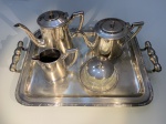 METAL PRATEADO  JOGO DE CHÁ MARCACA PRATA WOLFF, DECORAÇÃO FLORALNAS BORDAS, COMPOSTO POR UMA BANDEJA MEDINDO 49 CM. DE ALÇA A ALÇA X 33CM, UMBULE PARA SERVIR CAFÉ; UMA LEITEIRA; UMA CREMEIRA; UM PORTA GELÉIA EM VIDRO COMTAMPA EM METAL. MEDIDA DO BULE MAIOR: 16 CM DE ALTURA X 22CM.