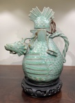 ARTE ORIENTAL - CHALEIRA DRAKE CELADON HIEROGLÍFICO. RESTAURO NA TAMPA. PEÇA DE COLEÇÃO ELABORADA DE FORMA ENGENHOSA E COM RIQUEZA DE DETALHES. MEDIDAS; 24,3 DE ALTURA POR 10,3 CM DE DIÂMETRO. O ORIGINAL FAZ PARTE DO TESOURO NACIONAL DO SÉCULO XII  NO MUSEU NACIONAL DA CORÉIA. *NOTA. O DRAGÃO CELADON VOADOR É UM ANIMAL IMAGINÁRIO COM CABEC1A DE DRAGÃO, CORPO ESCAMADO E CALDA DE ENGUIA. A CABEÇA DESEMPENHA O PAPEL DE "BOCA" POR ONDE VERTE O LÍQUIDO QUENTE. SUAS BARBATANAS FRONTAIS SÃO AFIADAS E AS LATERAIS CUMPREM A FUNÇÃO DE ASAS. A ALÇA É UM ELEMENTO ROBUSTO NO CONJUNTO E TEM COMO FORMA DUAS HASTES DE LÓTUS QUE COM SEUS RAMOS SUPORTAM E DÃO ESTABILIDADE AO CONJUNTO.