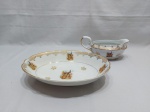 Travessa oval funda e molheira em porcelana Real com estampa de pavão e detalhes ouro. Medindo a travessa 28,5cm x 20,5cm x 6cm de altura.