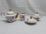 Jogo de 4 peças de servir chá em porcelana Real flor rosa, friso ouro, gravado "M.P.". Medindo o bule 12cm de altura.