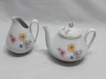 Jogo de bule de chá e leiteira em porcelana Real floral com friso ouro. Medindo o bule 11cm de altura.