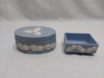 Caixa oval e porta trecos retangular em porcelana azul com relevo branco, ao gosto Wedwood. Medindo a caixa oval 14,5cm x 9cm x 5cm de altura.