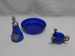 Lote composto de sino sineta de mesa, bowl e cinzeiro, peças em vidro azul cobalto e acabamento em metal. Medindo o bowl 16,5cm de diâmetro x 4cm de altura. Bowl com leve bicado.