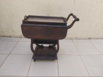 Carrinho de chá em madeira com rodízio e bandeja retangular. Medindo fechado 75cm x 40cm x 77cm de altura e 70cm de comprimento aberto. Com leve falha na folhagem.
