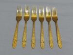 Jogo de 6 garfos de mesa em metal dourado com flores em relevo. Medindo 18,5ccm de comprimento.