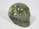 Pedra esculpida em forma de crânio na cor verde. Medida 6 x 8 x 5 cm.