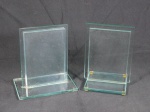 Dois porta-retratos em vidro translúcido. Medidas 17,5 x 15,5 x 10,5 cm e 17,5 x 12,5 x 10,5 cm.