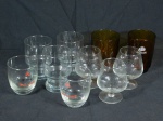 Dez copos e taças em vidro translúcido com logos de diversas bebidas.