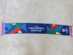Faixa comemorativa da CONMEBOL - "Copa América Brasil 2019", Confeccionada em tecido acrílico. Fabricada em Portugal. Comp. 128cm.
