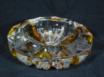 Cinzeiro em grosso bloco de cristal doublé com decoração na cor âmbar. Apresenta imperceptíveis bicados na lateral. Med. 4 x 14cm.