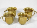 Quatro xícaras para café em metal dourado.