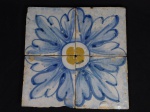 Quatro placas de azulejos hidráulicos que juntos formam desenho floral em policromia. Medida 14 x 14 cm.