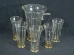 Jarra e 5 copos em vidro translúcido decorados com frisos brancos e dourados, anos 50. Apresentam desgastes na douração. Alt. do jarro 25 cm.
