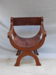 Cadeira dita savonarola, estrutura de madeira clara, pés e assento no formato meia lua, assento em couro rígido e encosto em couro maleável. Alt 80cm.