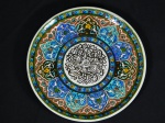 Medalhão em faiança vitrificada, decorado com mandala em policromia. Localizado no fundo, Turquia, Kütahya. Apresenta dois lascados no fundo. Diam. 26cm.