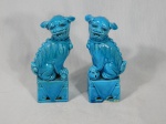 Casal de cães de fó em porcelana vitrificada na cor azul. Um deles apresenta lascado na base. Alt. 15cm.