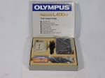 Micro gravador  fabricante OLYMPUS, modelo L400. Acompanha estojo original, capa protetora, mini fita cassete e controle remoto. Funcionamento desconhecido e sem garantias. Med. da caixa 3 x 16 x 18,5 e do gravador 2 x 7,5 x 5cm.