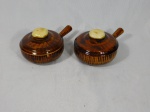 Dois bowls em cerâmica vitrificada e policromada em tons de marrom na forma de panelas com tampa. Med. 8 x 17 x12cm.