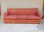Sofá para 3 lugares, estrutura de madeira forrada tecido na cor vermelha, almofadas do assento soltas. Forração com desgastes do tempo. Med. 205 x 76 x 80cm.