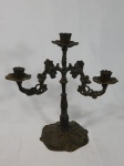 Candelabro para 3 velas em bronze, base decorada com volutas, haste torneada e braços decorados com flores e folhagens. Apresenta desgastes do tempo. Med. 22 x 18 x 11,5cm.