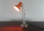 Luminária de bancada com articulação sanfonada, haste e base em metal cromado e copo na cor laranja. Dimensões: 59x17 cm.