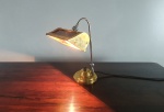 Antiga luminária de bancada, peça feita em metal dourado e metal cromado, articulação de direcionamento da luz. Dimensões: 38x23 cm.