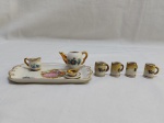 Lote de miniaturas composto de bandeja, bule, leiteira e xícara em porcelana francesa de Limoges e 4 canecas em porcelana. Medindo a bandeja 12,5cm x 7,5cm.