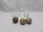 Lote composto de 3 bolas decorativas em porcelana e 2 vasos floreiras em vidro incolor. Medindo o vaso quadrado 10,5cm x 10,5cm x 15,5cm de altura.