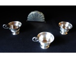 Três xícaras espessuradas à prata com bordas lavradas e repuxadas, (uma sem a asa) Eberle,  um porta guardanapos em inox. Este lote encontra-se em Nogueira, Petrópolis.