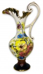 EUROPA SEC XX - Elegante ânfora em porcelana branca esmaltada ricamente adornada com motivo floral em policromia e contorno em vibrante ouro, possui alça no formato de voluta. Borda em movimento. Apresenta sinais de restauro. Mede 21cm de comprimento x 31cm de altura.