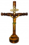 Gracioso crucifixo para mesa com estrutura madeira, adornado com aplique em metal dourado e imagem de jesus Cristo em policromia. Localizado na base. Mede 14cm de largura  x 21cm de altura.