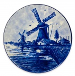 HOLLAND - Gracioso prato decorativo para parede em porcelana branca esmaltada ricamente adornada com cena rural com moinhos na cor azul royal pintado a mão. Assinado e localizado na base. Mede 14cn de diâmetro.