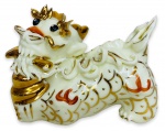 CHINA - Inusitada escultura em porcelana esmaltada na cor creme, representando figura folclórica de dragão chinês em rica policromia e contorno em vibrante ouro. Possui discreto bicado. Mede 7cm de altura x 11cm de comprimento.